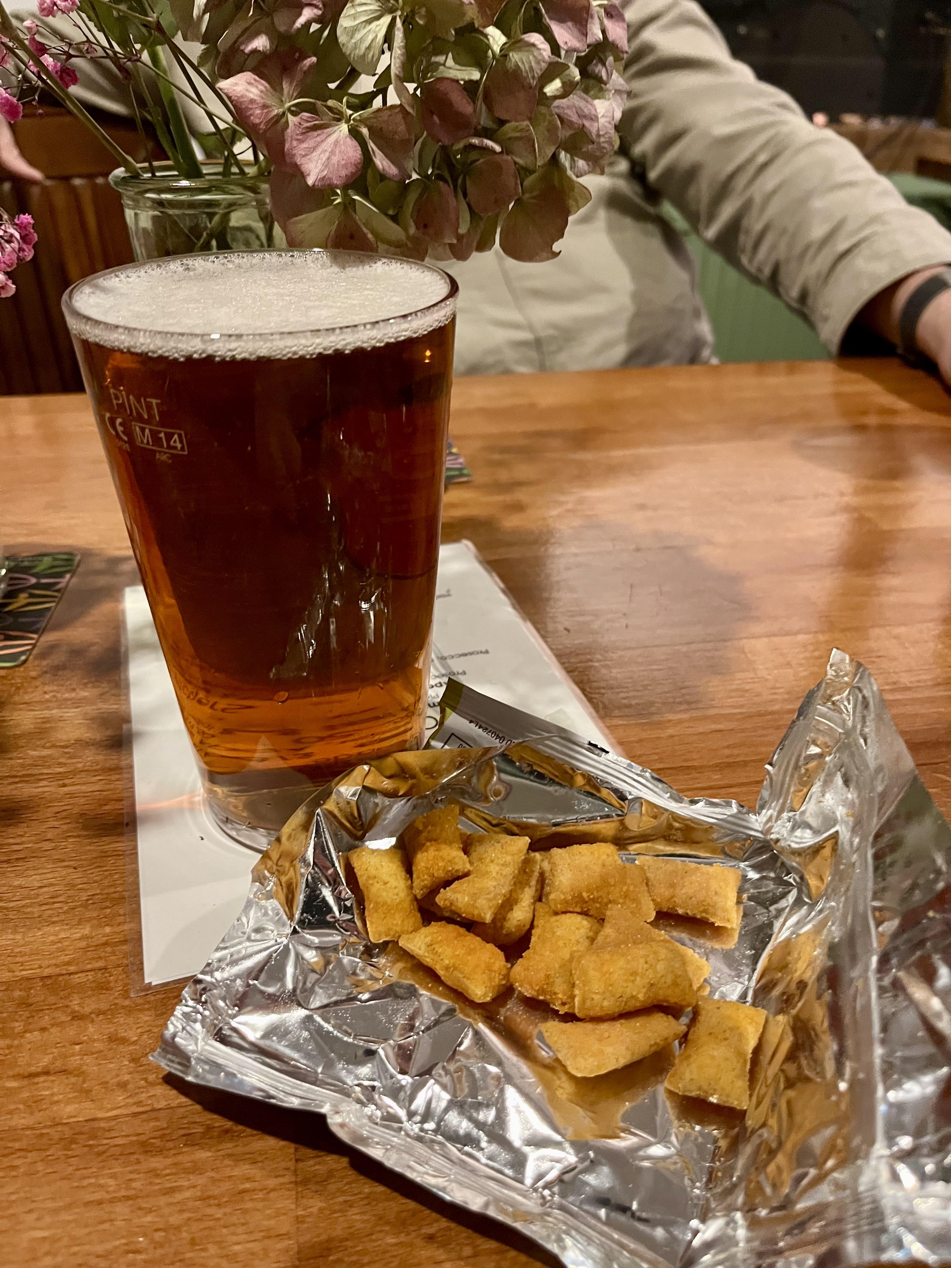 A pint of beer and a bowl of scampi fries